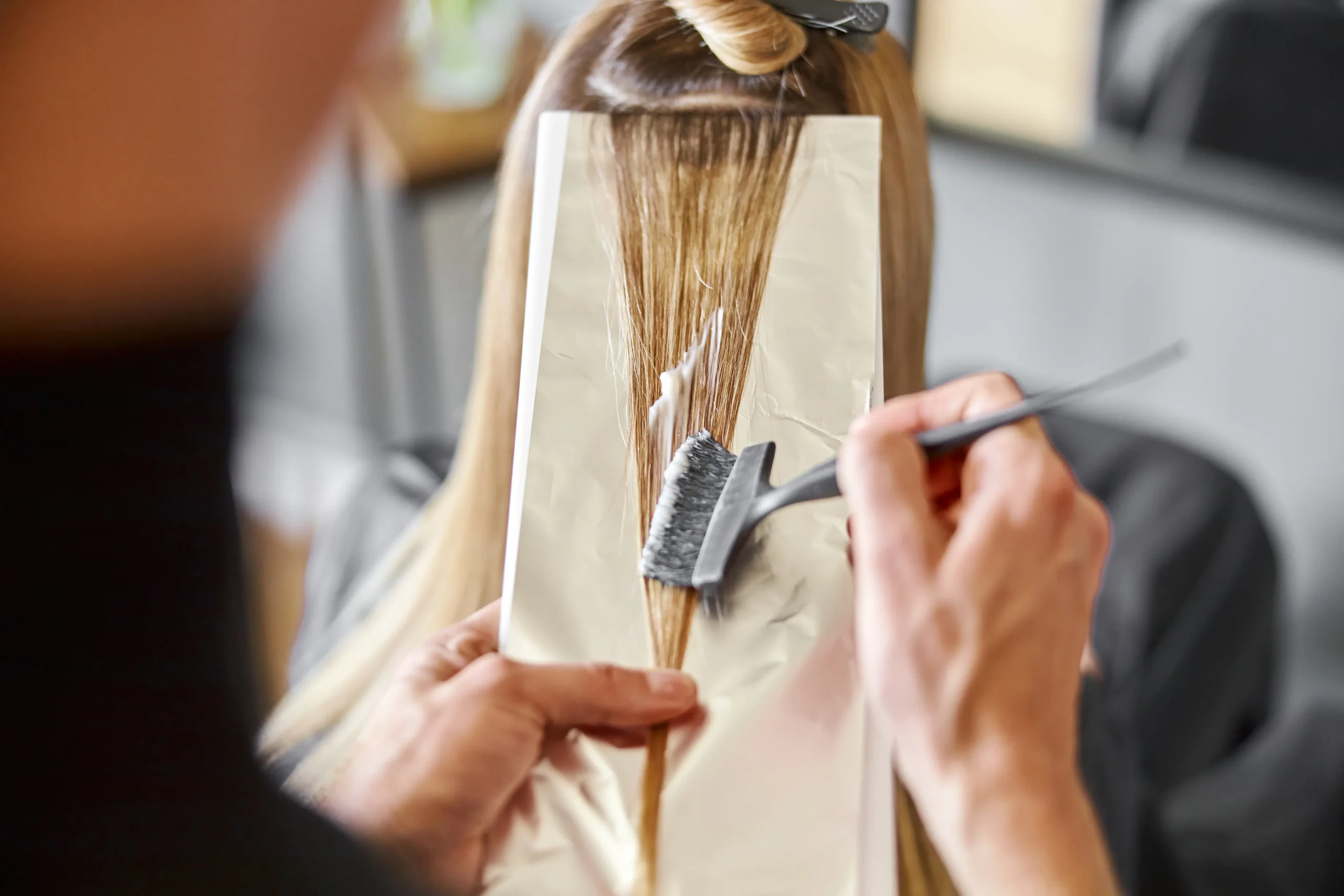 Peluquero poniendo mechas con papel de plata